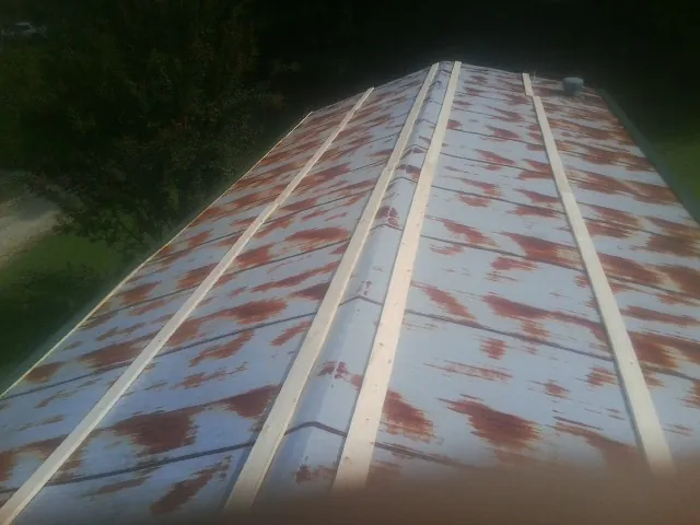Rusted metal roof panels with new wood purlins before replacement — Storm Damage Roof Repair in Tarrytown by Roofing Brothers