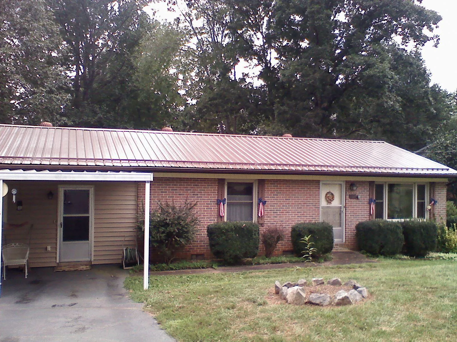 Bronze metal roof and carport on a brick ranch home — Roof Repair work by our crew in Tarrytown